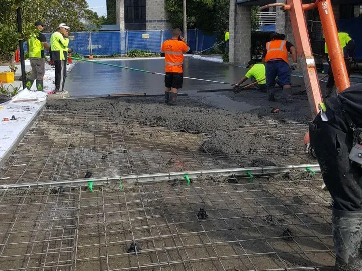 Concrete being placed over mesh with a pump line