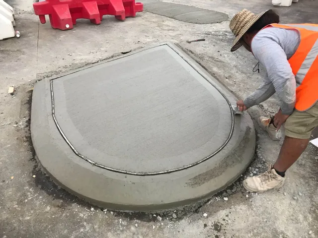 Tradesman finishing a concrete pit surround